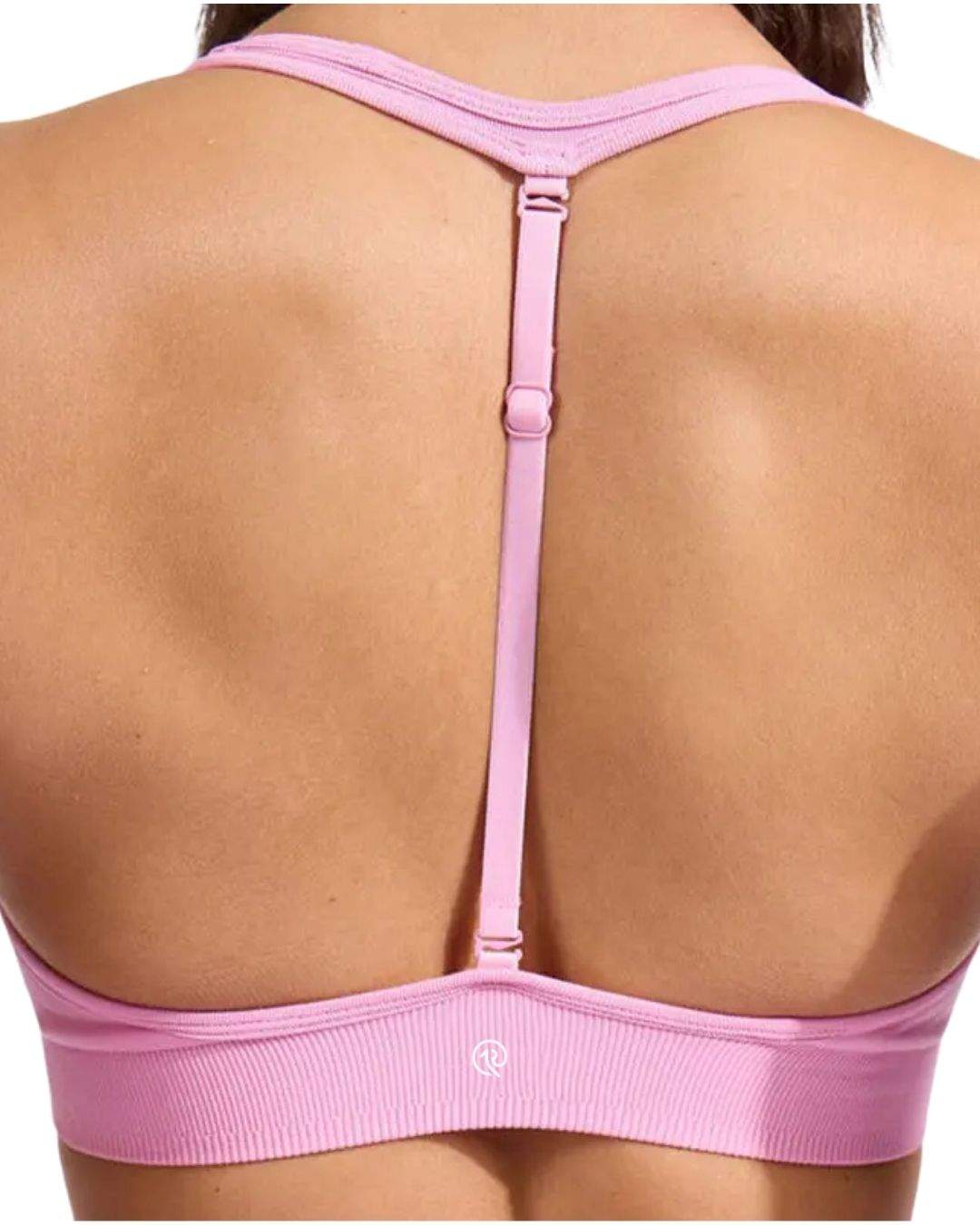Back view of a pink ORU HALTER SPORTS BRA with adjustable center-back strap and soft fabric blend.