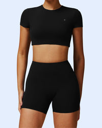 Front view of woman wearing black ORU Phul Short with medium scrunch, mid-rise waistband, and elasticated comfort fit