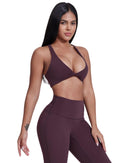 Woman wearing ORU LEGACY SPORTS BRA in deep purple with wide shoulder straps and twist folding front design