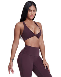 Woman wearing ORU LEGACY SPORTS BRA in deep purple with wide shoulder straps and twist folding front design