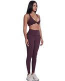 Woman wearing purple ORU LEGACY SPORTS BRA with wide straps and matching leggings, showcasing seamless, breathable, quick-drying fabric and twist folding front design.