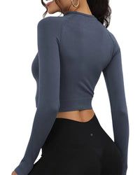 Back view of woman wearing slim fit ORU cropped long sleeve top with thumb hole cuffs, designed for running and training