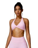Woman wearing pink Oru Mika Halter Sports Bra with halter neck support and matching high-waisted leggings