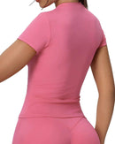 Back view of woman wearing pink ORU FITTED TOP with round neckline, slim fit, and breathable fabric