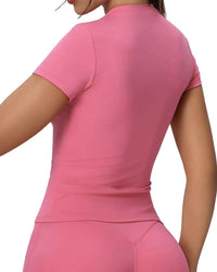 Back view of woman wearing pink ORU FITTED TOP with round neckline, slim fit, and breathable fabric