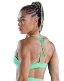 Back view of woman wearing ORU SPARK SPORTS BRA in cool mint with seamless design and strappy back